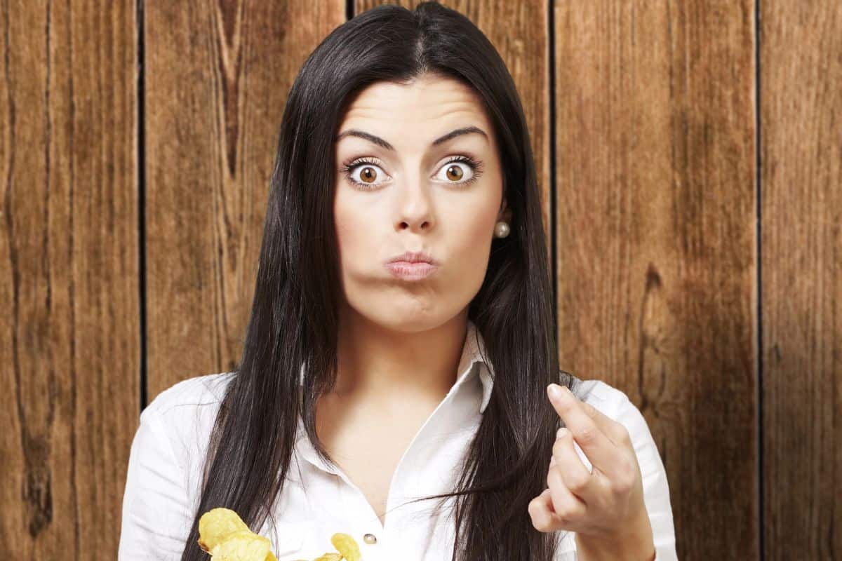 woman holding chips looking surprised