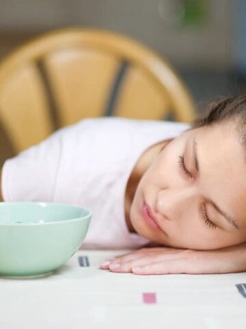 woman sleeping with coffee at table