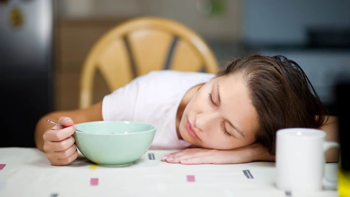 woman sleeping with coffee at table