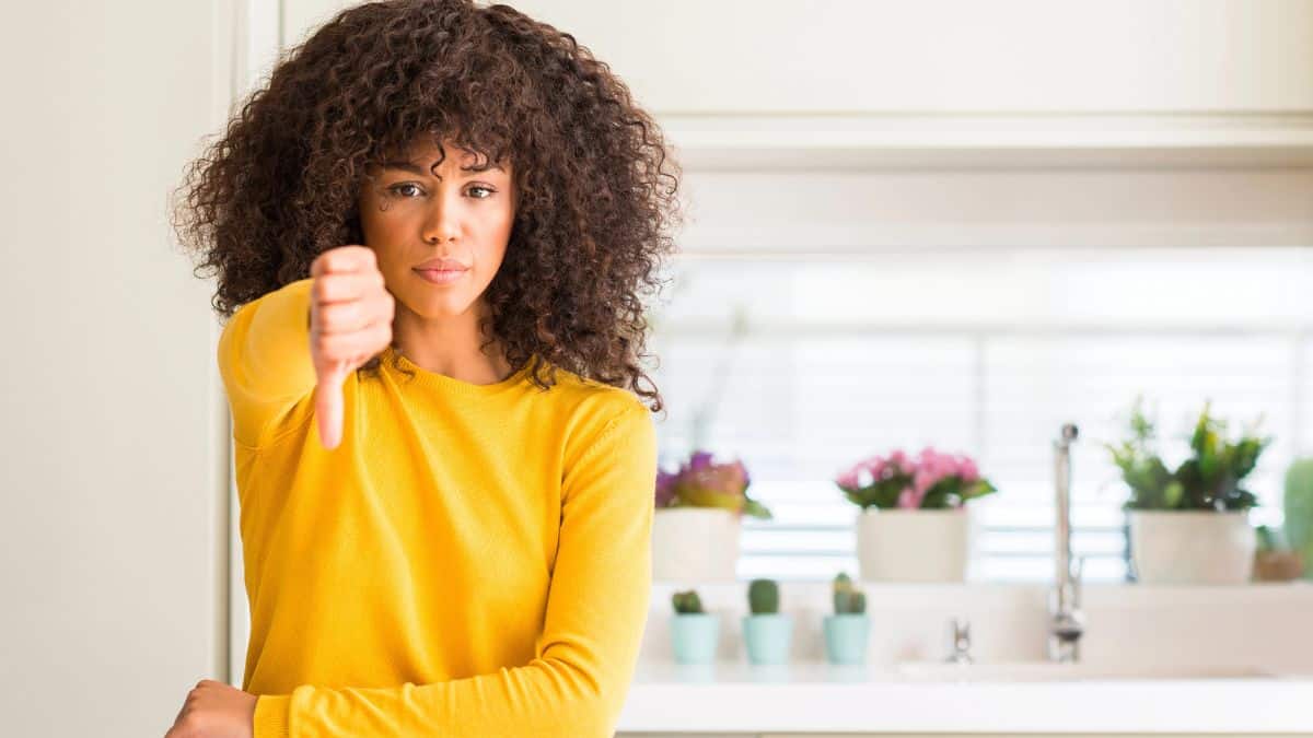 woman with thumbs down in kitchen
