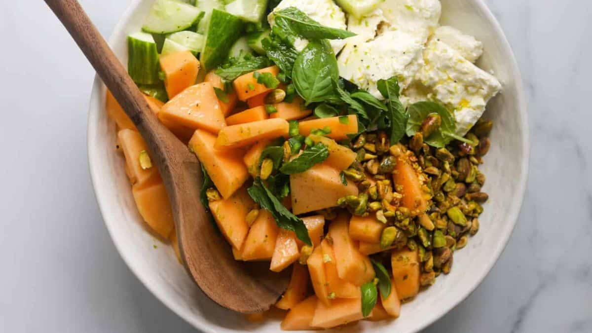 A serving of cantaloupe salad with feta and crushed pistachios. 