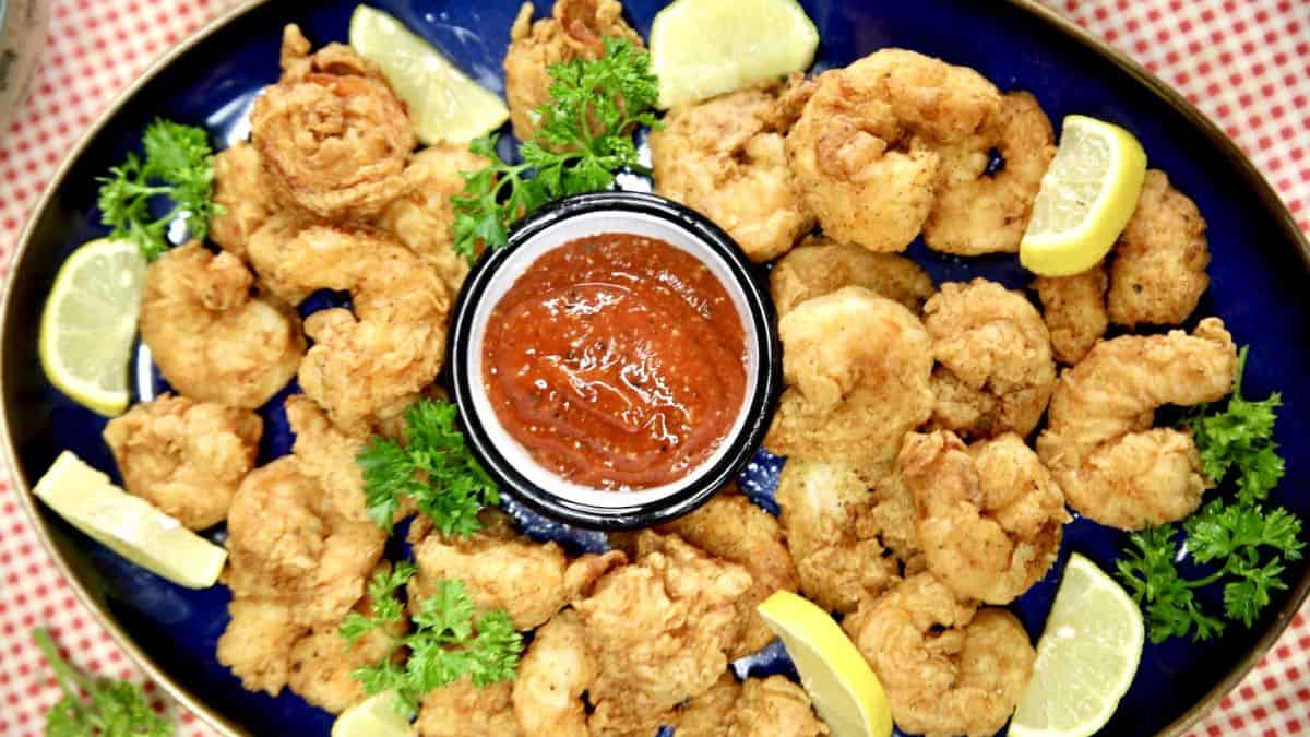 Fried shrimp garnished with sliced lemons, fresh parsley and dip.