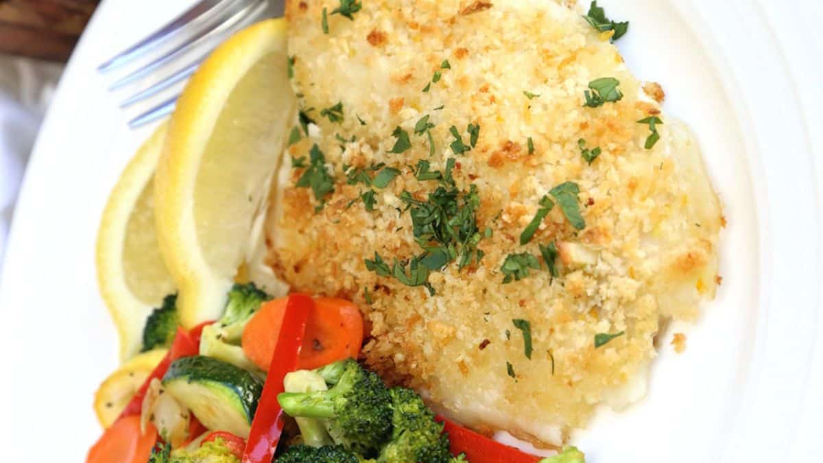 A serving of oven baked garlic crusted tilapia with a side of mixed vegetables. 