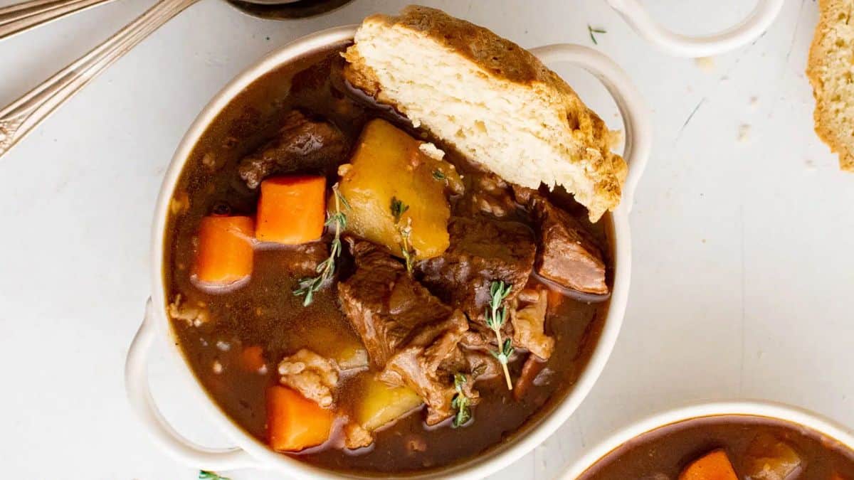 A bowl of Guinness beef stew with bread on the side.