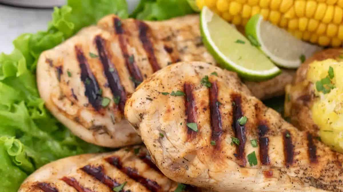 Guinness grilled chicken with sliced of lime and corn on the side.