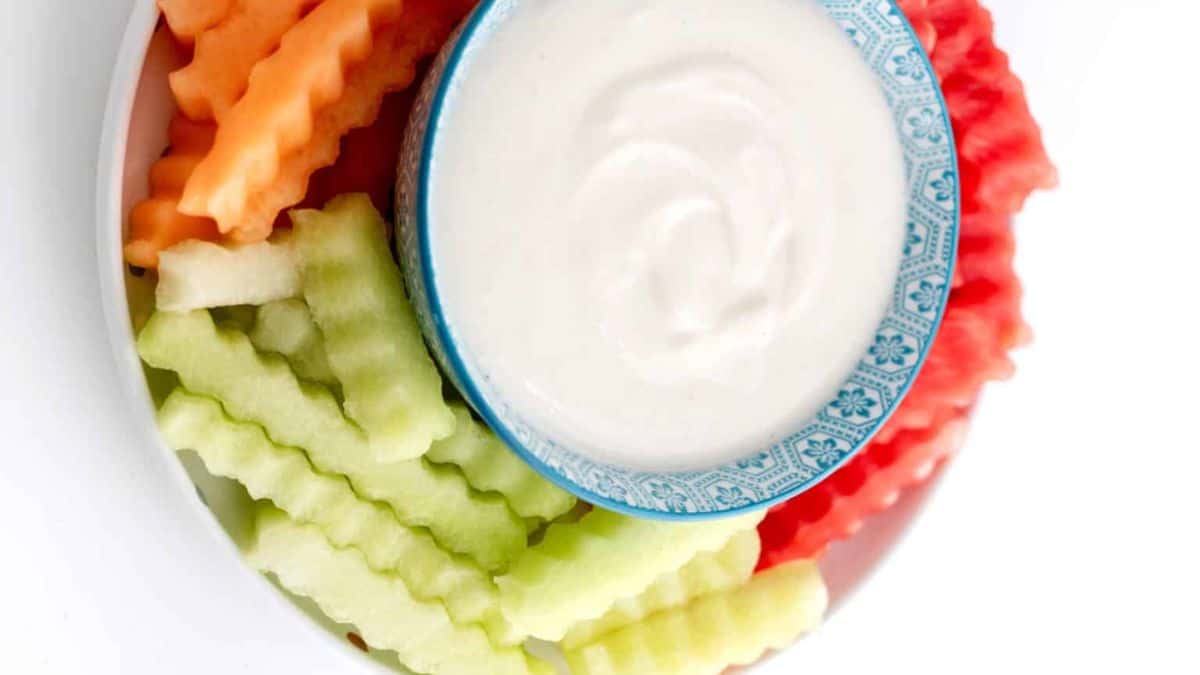 A serving of fruit fries with some creamy yogurt dip.