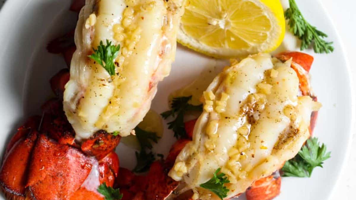 Lobster tails with sliced lemon on the side.