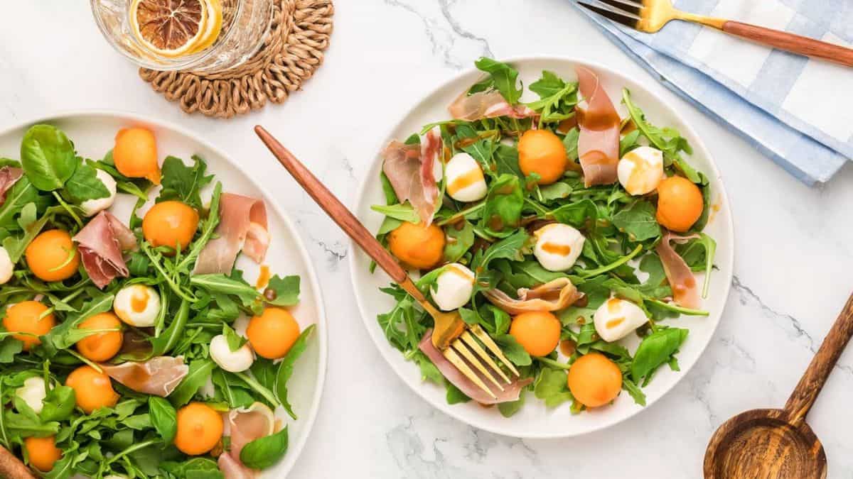 Two plate-full servings of melon prosciutto salad. 