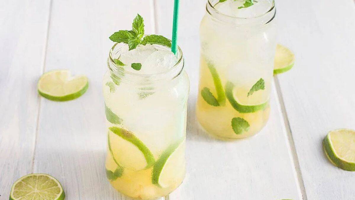 Glasses of mint pineapple ginger mojito mocktail with slices of lime.