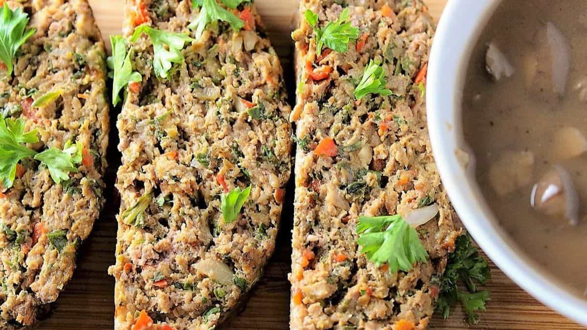 3 slices of meatloaf served with gravy on the side. 