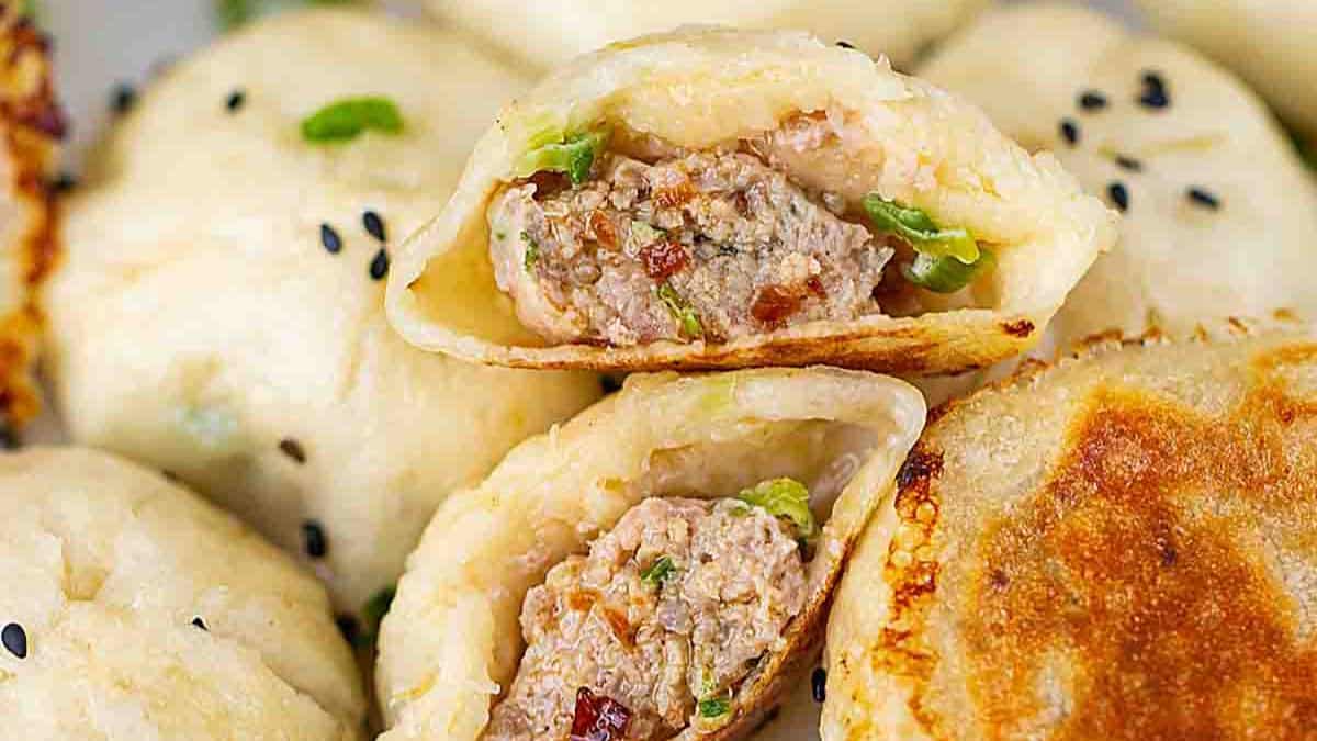 Pan-fried buns cut in a half drizzled with its sauce.