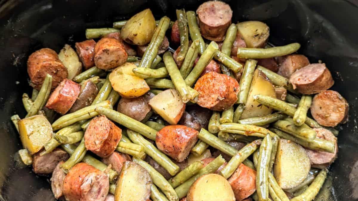 Cajun sausage, green beans, and potatoes in a slow cooker.