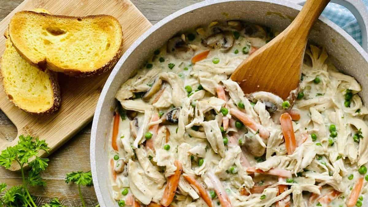 Turkey a la King in a serving bowl, with some bread on the side.