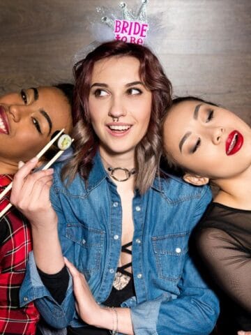 three people holding sushi