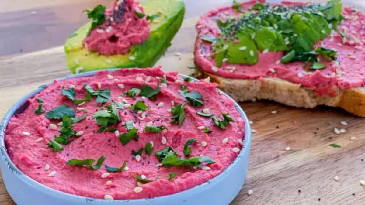 Beets & Wasabi Hummus served in a bowl with bread on the side. 