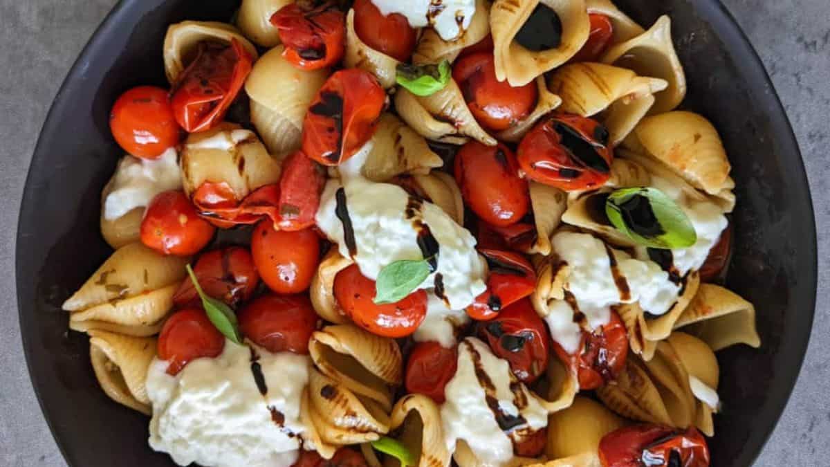 A bowl of burrata pasta with blistered tomatoes,