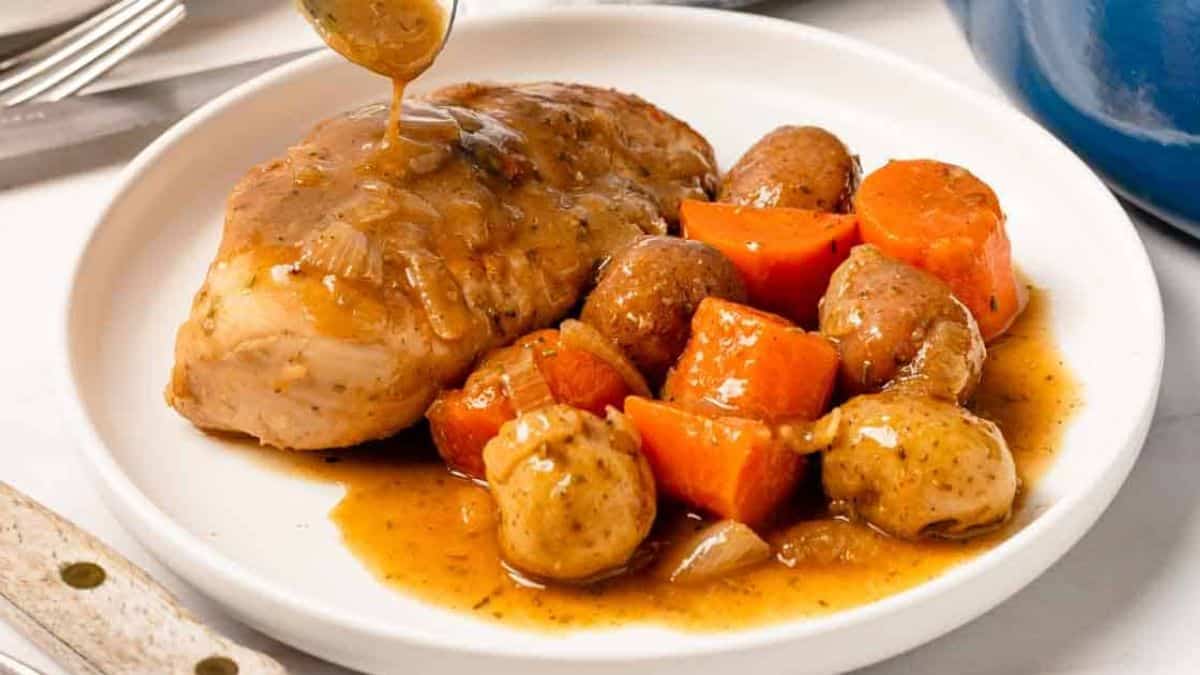 A serving of Dutch oven chicken breast with potatoes and vegetables.