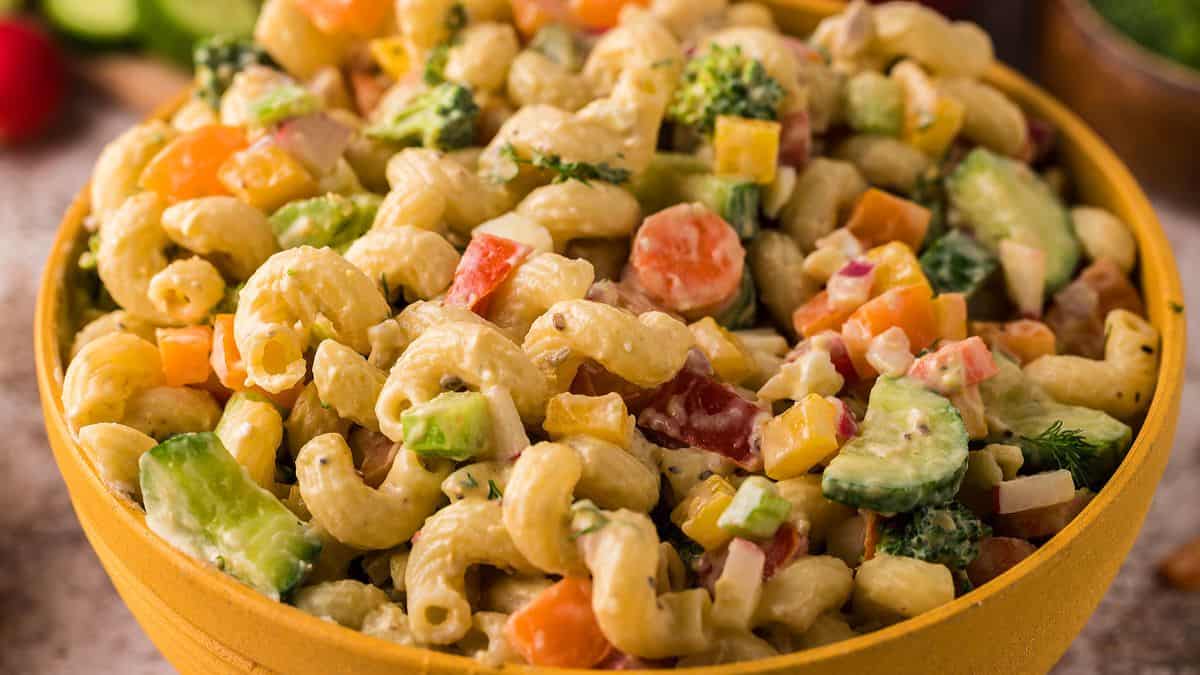 A bowl of garden veggie macaroni salad and creamy avocado dressing.