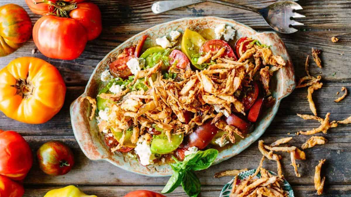 Heirloom Tomato Salad with Blue Cheese and Fries Shallots served on a plate.