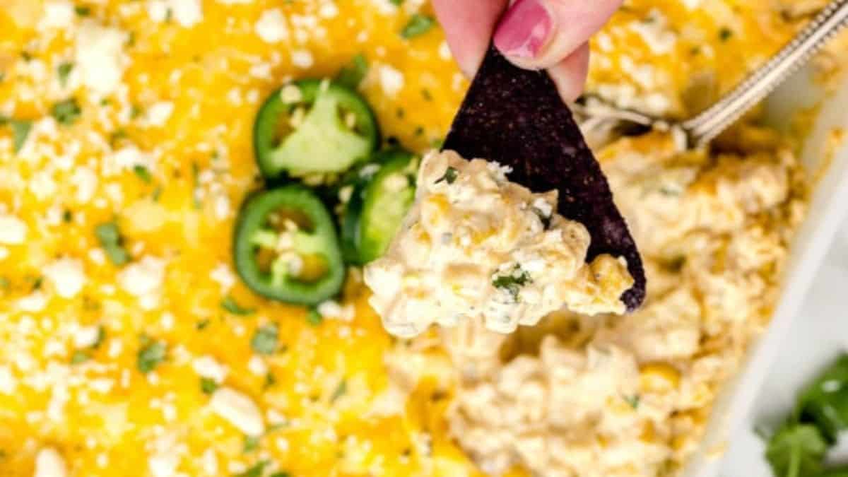 Mexican Corn Dip served in a baking dish with some nachos. 