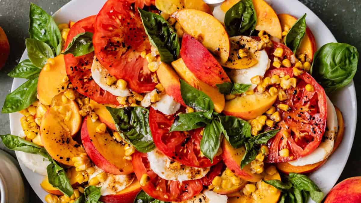 A plate of peach caprese salad with balsamic glaze