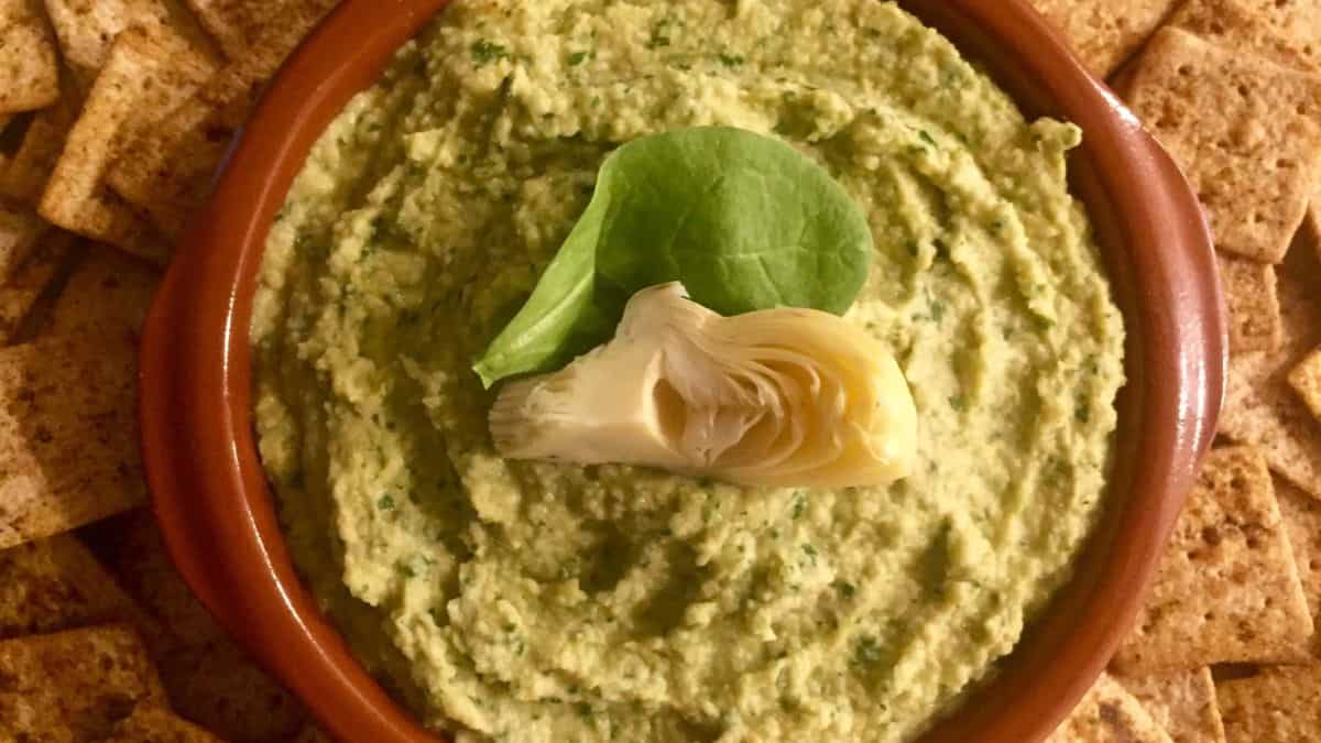 A bowl of spinach and artichoke hummus with sneaky superfoods.