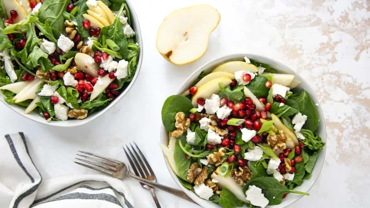 A bowl of spinach, pear, and feta salad