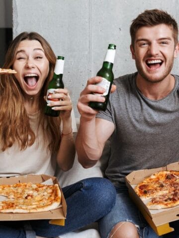 couple excited with pizza and beer
