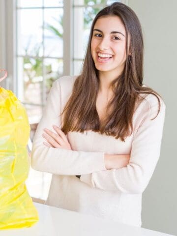girl smiling with trash bag