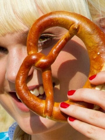 woman looking through large pretzel