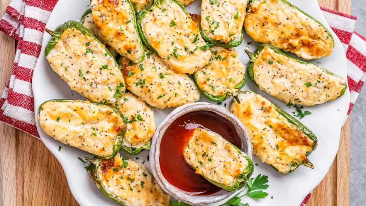 Baked Jalapeno Poppers served on a plate with a dip.