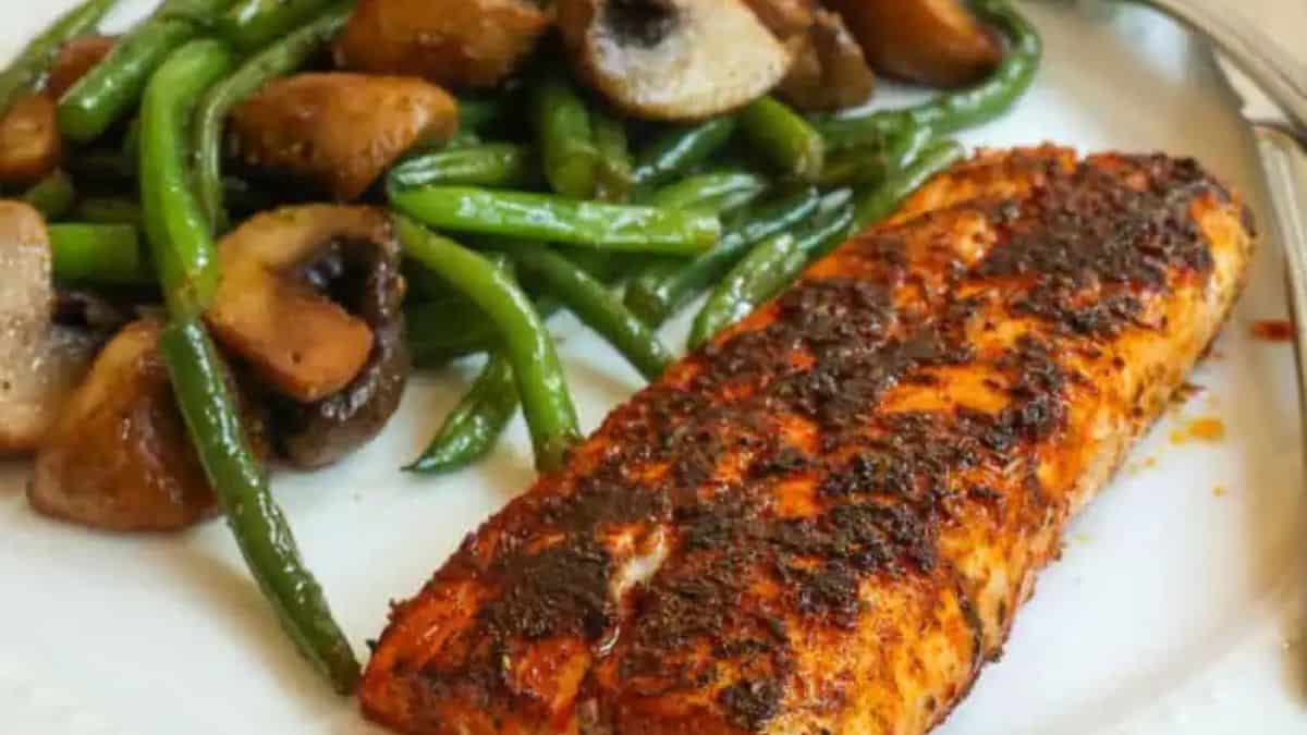 Blackened Mahi Mahi with beans and mushroom side served on a plate.