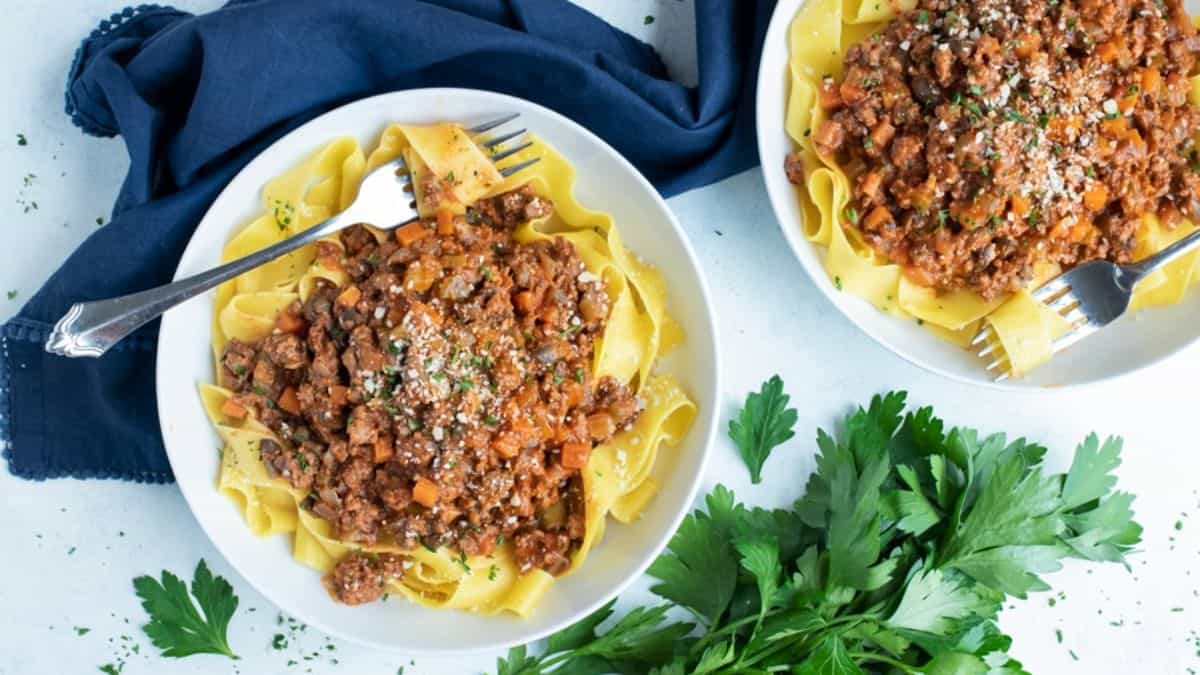 Bolognese Sauce on top of pasta served on a plate. 