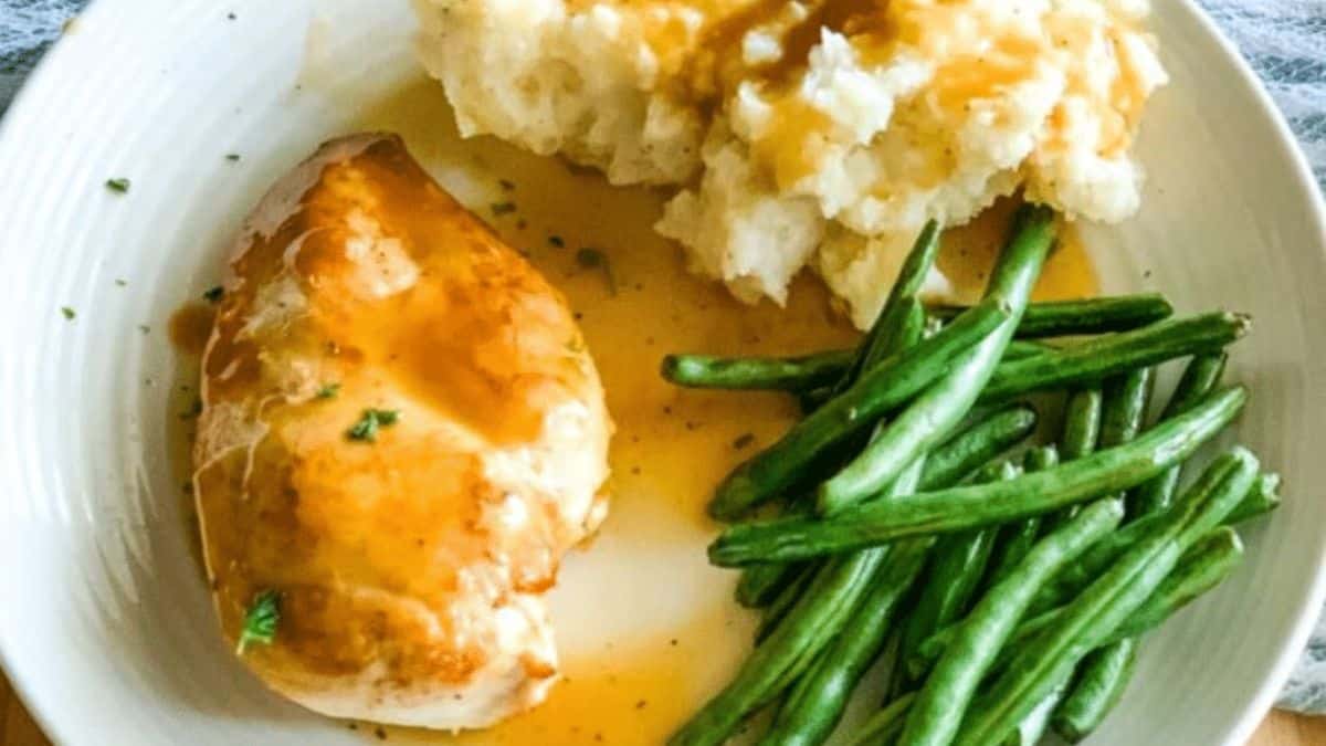 Chicken Breasts with Gravy served with mashed potatoes and string beans.