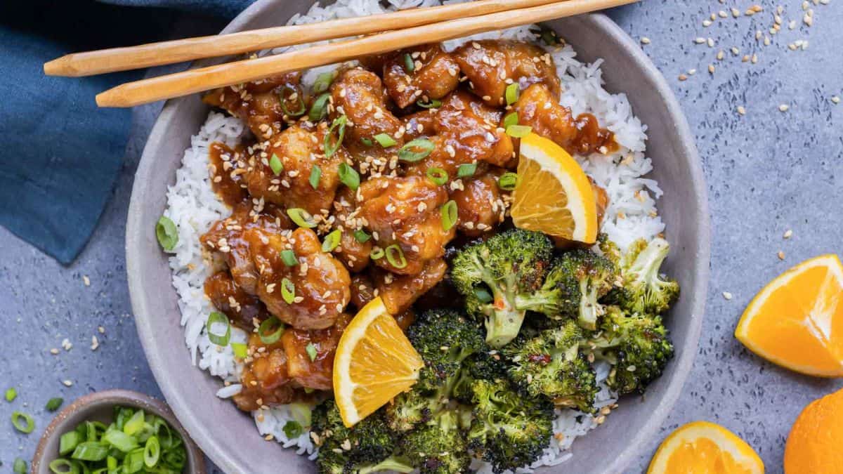 Crispy Orange Chicken served over a bowl of warm rice. 