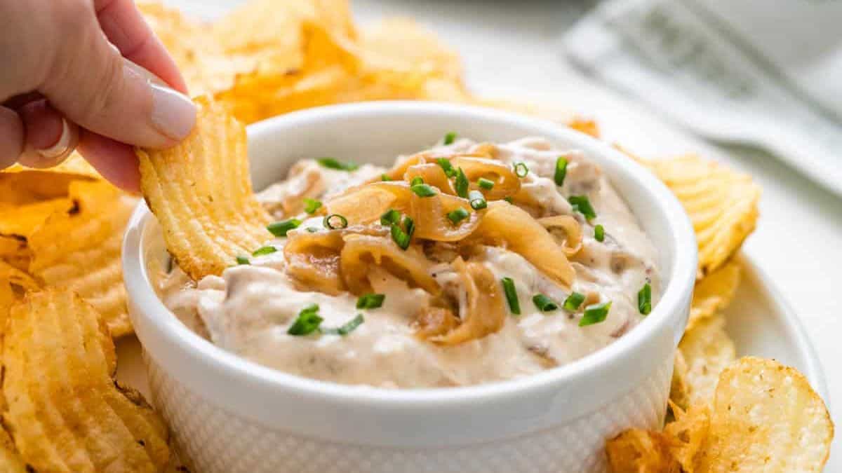 Sour Cream and Onion Dip served in a bowl with chips on the side.