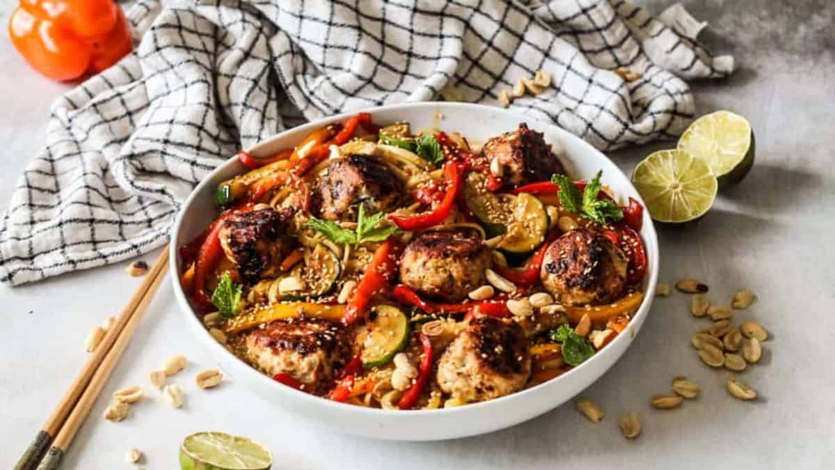 Spicy Peanut Noodles with Sesame Meatballs served in a bowl. 