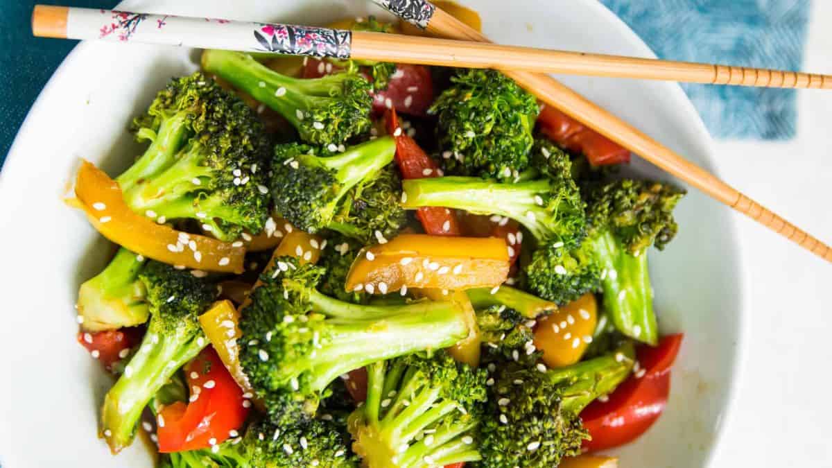 Teriyaki broccoli and peppers in a white bowl.