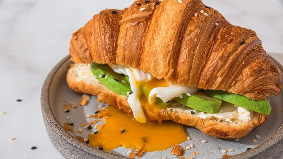 croissants stuffed with eggs, avocado, and spicy sauces