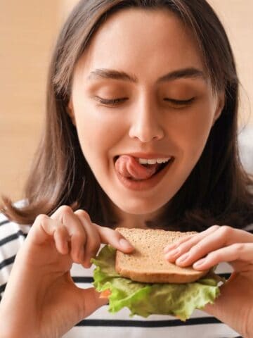 hungry woman eating sandwich