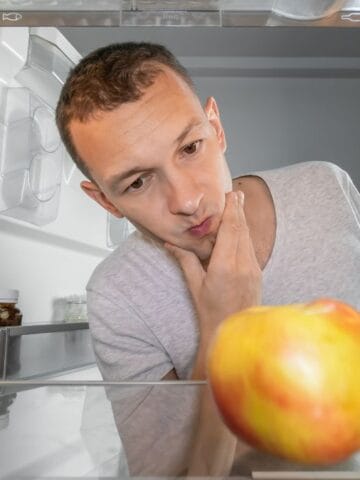man thinking with hand on chin in freezer