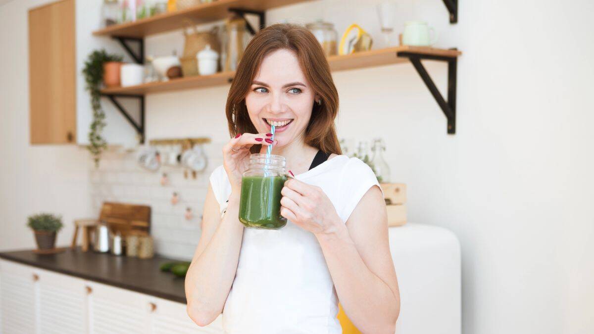 woman drinking green smoothie