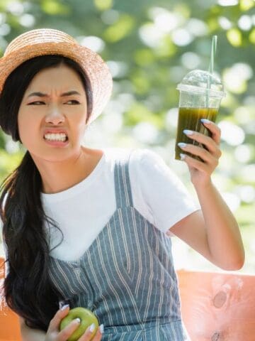 woman looking disgusted at drink