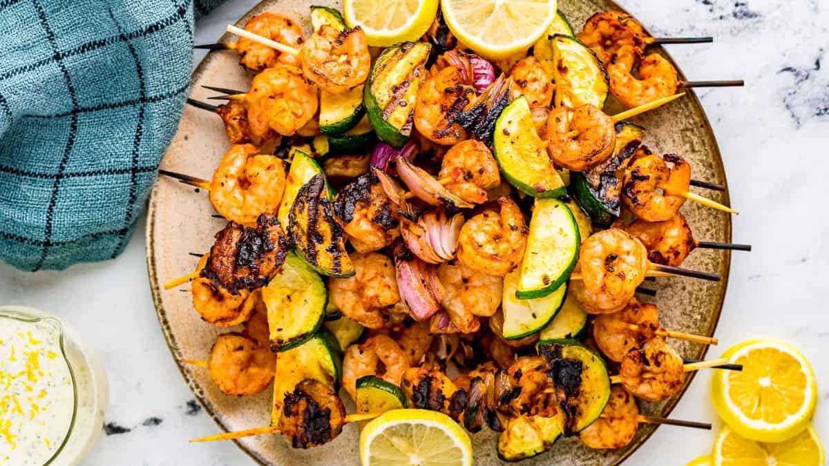 A couple of pieces of Spicy Marinated Grilled Shrimp Skewers served on a plate.