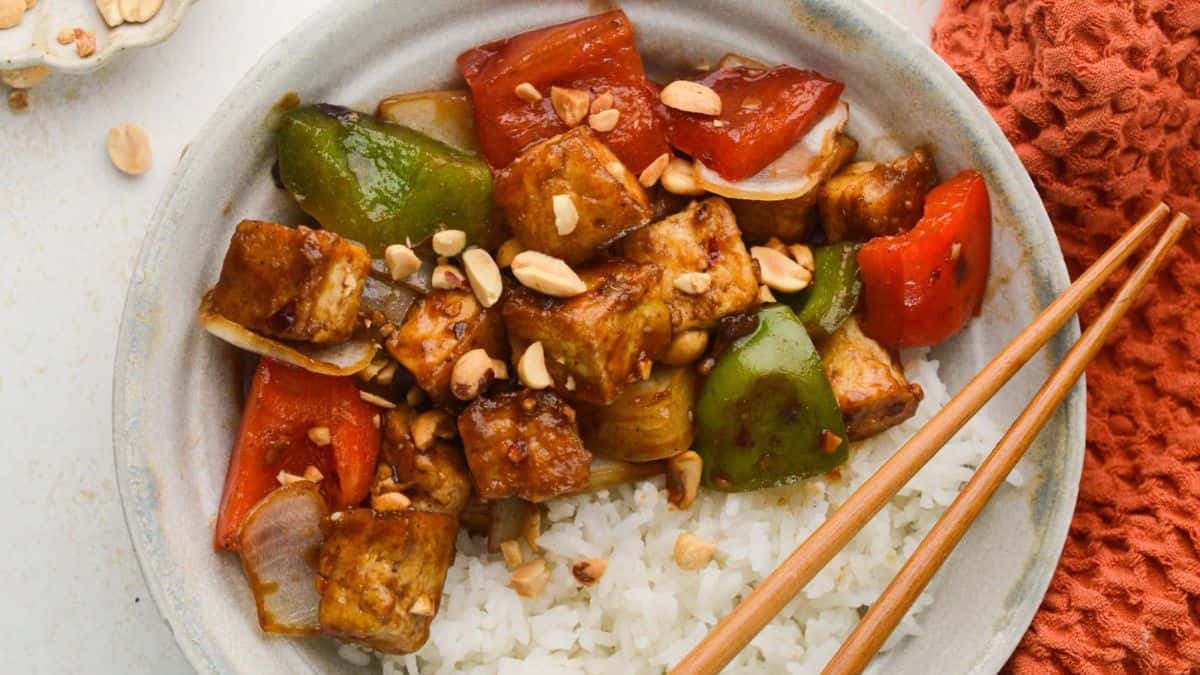 A serving of Kung Pao Tofu on top of a bowl of rice. 