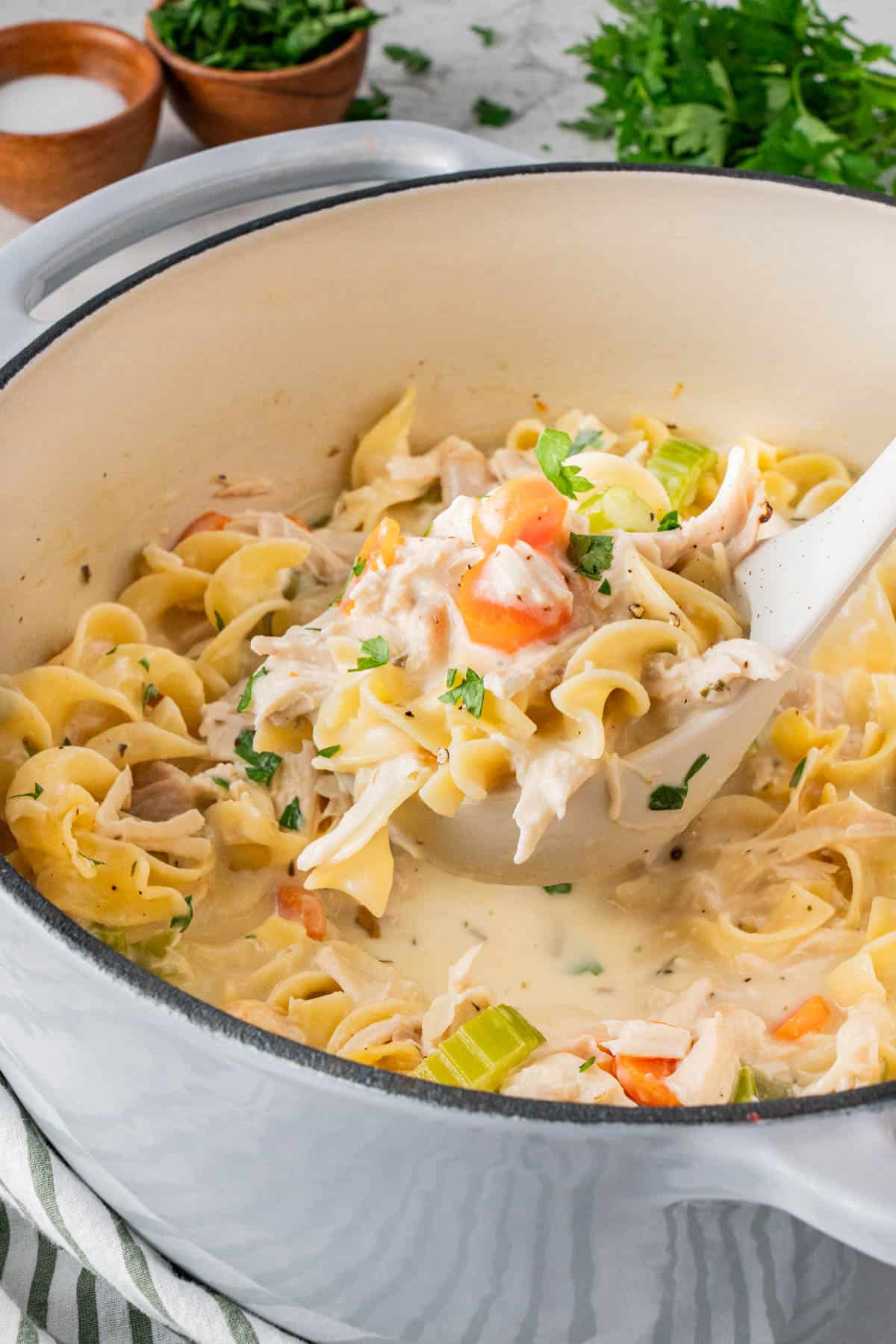 Close up shot of Creamy Chicken Noodle Soup With Rotisserie Chicken with a serving spoonful.