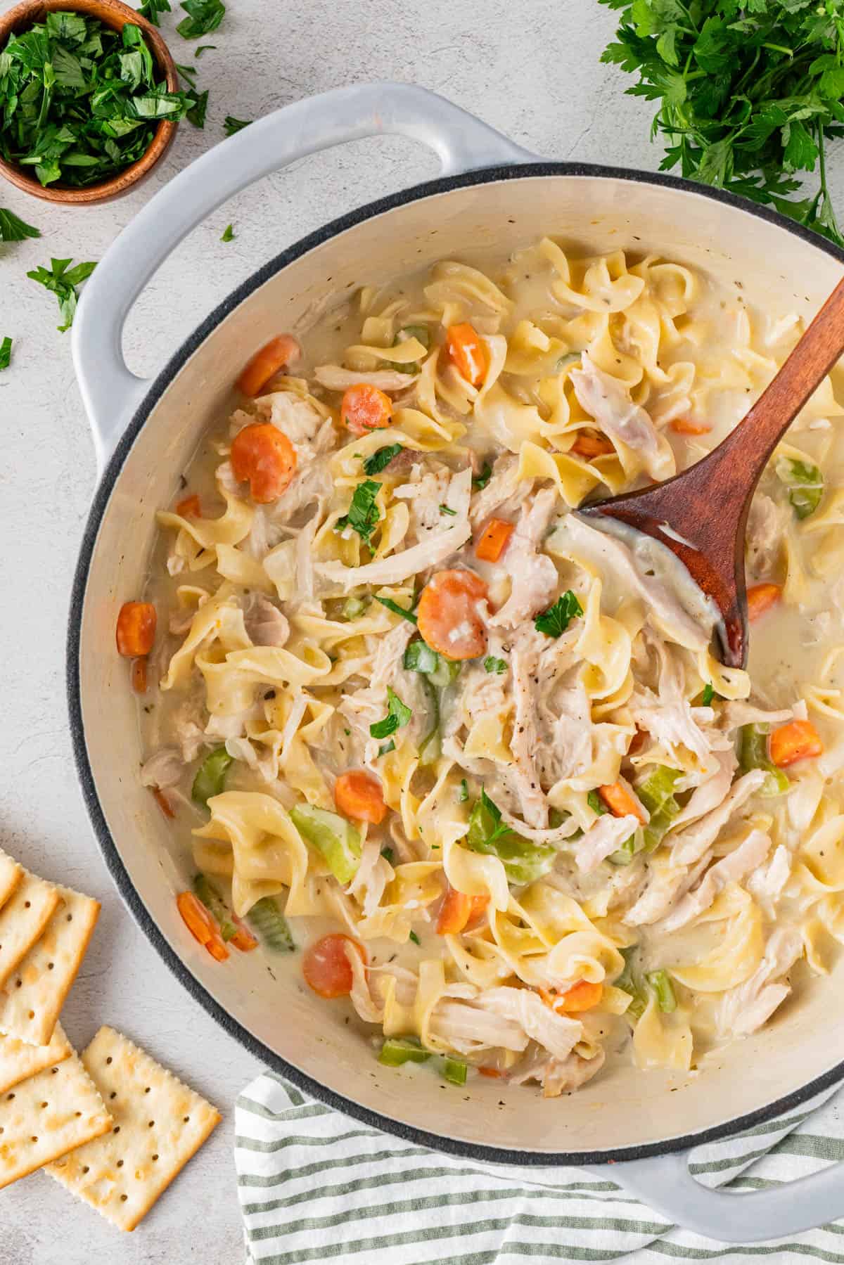 Creamy Chicken Noodle Soup With Rotisserie Chicken in a pot with a wooden spoon. 