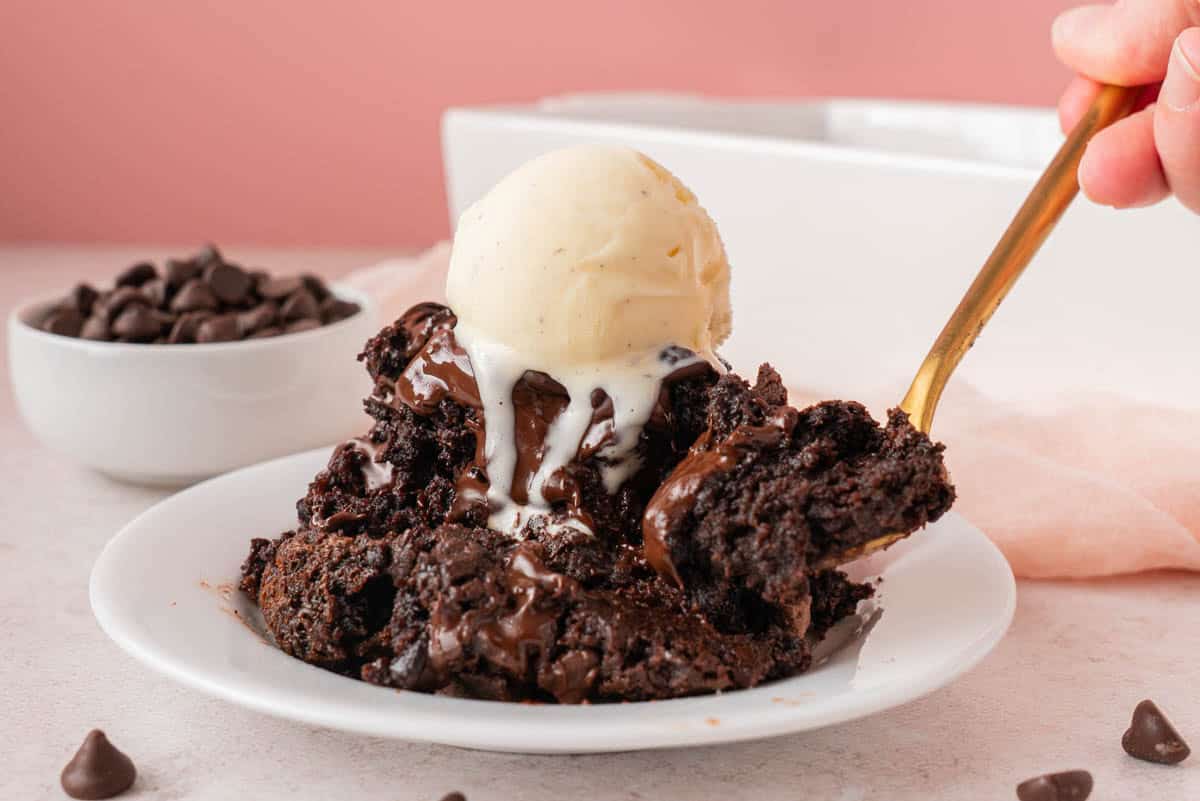 a serving of Chocolate Dump Cake With Pudding with a scoop of vanilla ice cream