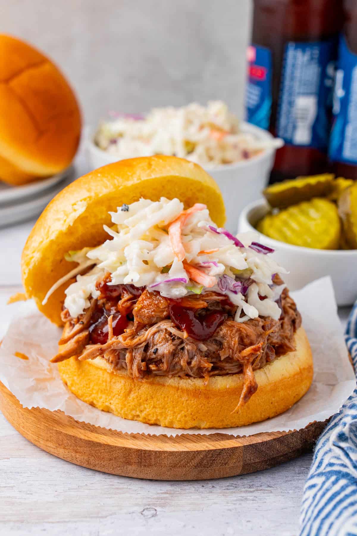 Crockpot BBQ Pork Shoulder Sandwich with coleslaw on a wooden plate
