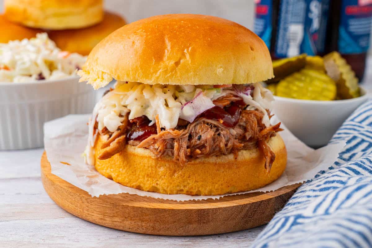 Crockpot BBQ Pork Shoulder Sandwich on a wooden plate.